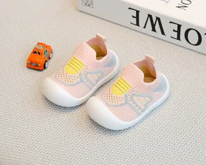 Breathable pink fly-knit baby walking shoes with non-slip soft soles in a lifestyle setting