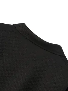Macro close-up view of a men's black waffle knit cardigan jacket collar and fabric texture