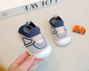 Detail view of breathable knit baby sock shoes with non-slip white rubber soles.