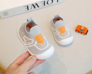 Macro detail of grey baby flyknit shoe with orange accents and flexible non-slip sole