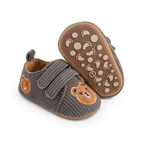Close-up of grey corduroy baby walker shoes with cute bear embroidery and non-slip sole
