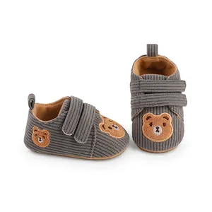 Detailed view of grey corduroy baby walking shoes featuring a cute embroidered bear