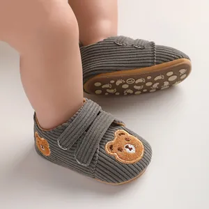 Detailed view of grey corduroy infant walking shoes featuring cute embroidered bear face