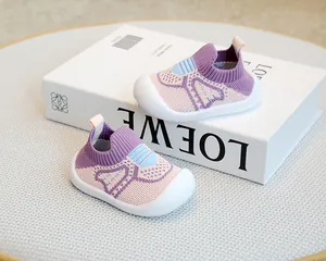 Close-up of purple baby flyknit walking shoes with anti-slip soft white rubber soles.
