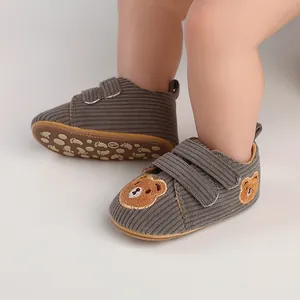 Detailed view of grey corduroy baby walker shoes with cute bear embroidery