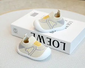 Close-up of breathable knit baby sock shoes with non-slip soft soles on white prop