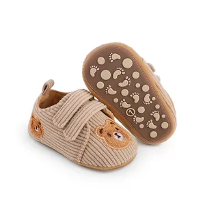 Detail of baby walking shoes showing soft corduroy texture and anti-slip sole pattern