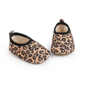 Vista detallada de zapatos suaves para bebé con estampado de leopardo y ribete elástico negro.