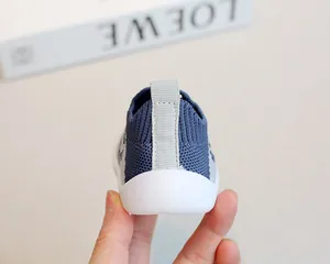 Detailed heel view of blue flying woven baby sock shoe with soft white sole