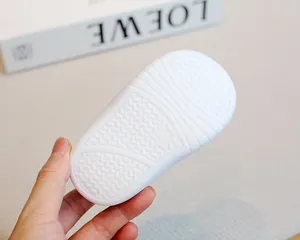 Detail view showing the textured anti-slip white sole of baby soft floor sock shoes.