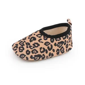 Vista detallada del patrón de leopardo y el borde negro en el zapato suave para bebés