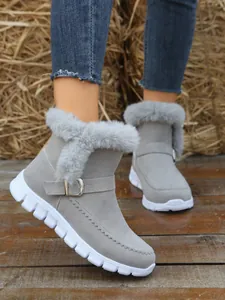 Detalle de botas de nieve grises para mujer con forro de piel sintética y hebilla