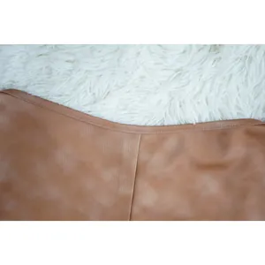 Close-up detail of the high-quality brown fabric and precise stitching on a skinny jumpsuit