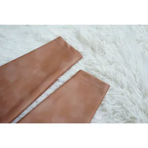 Close-up view showing the fine stitching and smooth bronze fabric of the tight jumpsuit