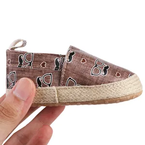 Detailansicht eines braun gemusterten Baby-Lauflernschuhs mit lustigem Schnurrbart-Print