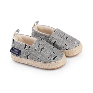 Détail de chaussures de marche bébé grises à motifs moustaches et semelle