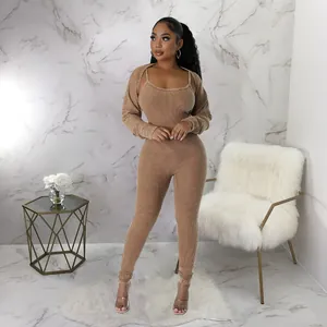 Full-length view of a model in a tan ribbed jumpsuit two-piece set with a shrug.
