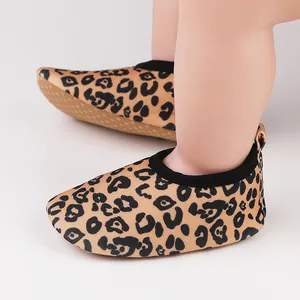 Close-up of baby leopard print walker shoes with non-slip soles on infant feet