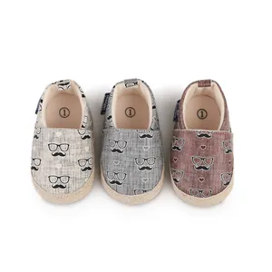Detailansicht von drei Paaren Babyschuhen mit Schnurrbart- und Brillenmuster in Farben
