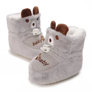 Close-up of plush grey baby winter boots with cute bear ears and baby embroidery