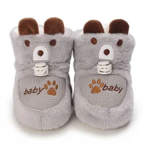 Detail of cute grey furry baby boots with bear ears and embroidered paw prints