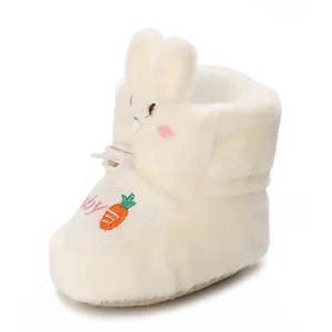 Détail de mignonnes bottines pour bébé en peluche blanche avec des oreilles de lapin