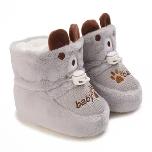 Close-up of grey plush baby booties with fleece lining and cute paw embroidery