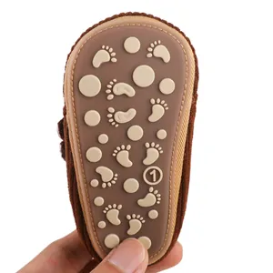 Close-up of anti-slip rubber sole for infant baby shoes with cute footprint pattern