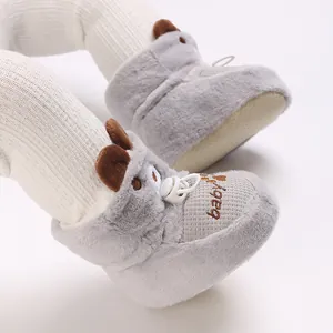 Close-up of grey plush baby winter boots with cute bear ears and adjustable toggle.