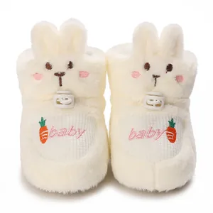 Gros plan de bottines en peluche blanche pour bébé avec oreilles de lapin et broderie
