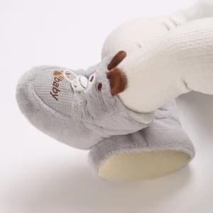 Close-up view of soft grey plush baby boots featuring cute animal ears and embroidery