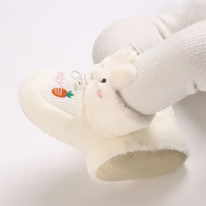 Gros plan détaillé de bottines de bébé en peluche avec oreilles de lapin et carotte