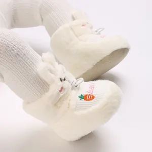 Détail de bottes d'hiver en peluche blanche pour bébé avec oreilles de lapin et carotte