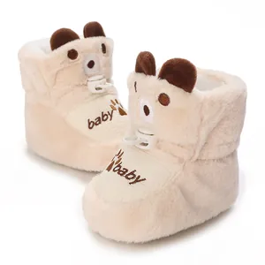 Detailed view of cream plush baby boots featuring cute bear ears and embroidered baby text