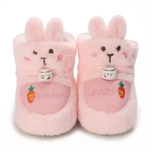 Détail de bottines pour bébé en peluche rose avec des oreilles de lapin et broderie
