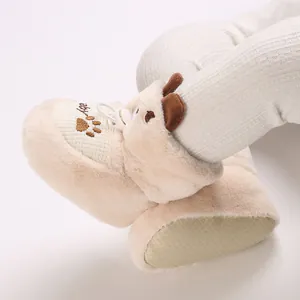 Close-up of warm beige plush baby boots with cute animal ears for infants 0-1 year.