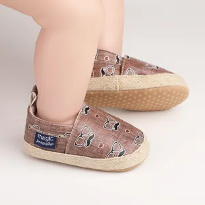 Detailansicht von Baby-Lauflernschuhen mit Schnurrbart- und Brillenmuster auf Stoff