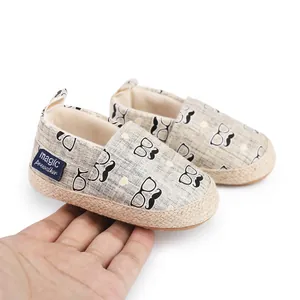 Detailaufnahme von Baby-Lauflernschuhen mit Schnurrbart- und Brillenprint