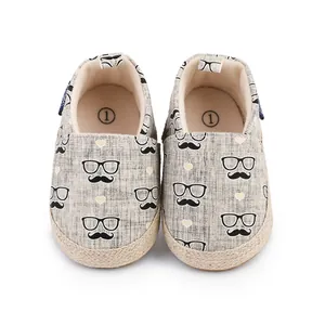 Detailansicht von Baby-Stoffschuhen mit Schnurrbart- und Brillenprint