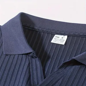 Nahaufnahme eines dunkelblauen gerippten Herren-Poloshirts inklusive dem Größenetikett