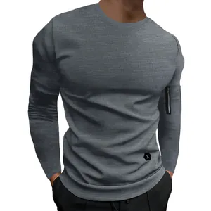 Détail d'un t-shirt gris à manches longues avec poche zippée décorative sur le bras