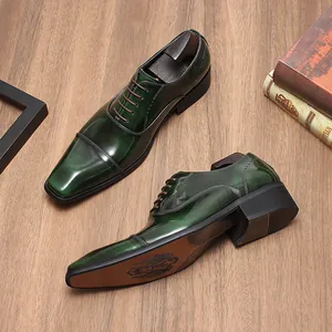 Detailansicht der hochwertigen grünen Herren-Lederschuhe mit Kappe auf Holzboden