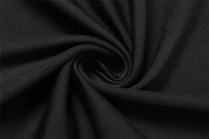 Detailed macro shot showcasing the fine texture and elastic quality of the black dress fabric