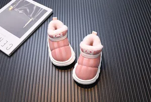 Nahaufnahme von stylischen rosa Kinder-Schneestiefeln mit warmem Plüschfutter und Puffer-Design.