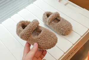 Nahaufnahme von braunen Plüsch-Mary-Jane-Schuhen für Kleinkinder auf weißem Display