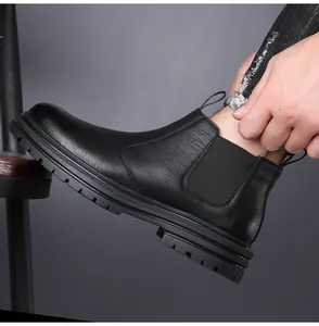 Close-up detail of a black leather Chelsea boot featuring a thick durable rubber sole