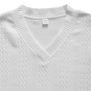 Detailansicht der Textur eines weißen Strickpullovers mit V-Ausschnitt und Zopfmuster