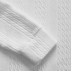 Detaillierte Makroansicht des aufwendigen weißen Zopfmuster-Jacquardmusters und der Manschette