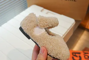 Nahaufnahme der weichen beige Lammfell-Textur an einem gemütlichen Kleinkind-Winterschuh.