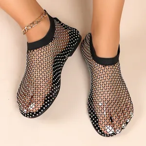 Detailansicht der schwarzen Mesh-Sandalen mit funkelnden Strasssteinen und flacher Sohle